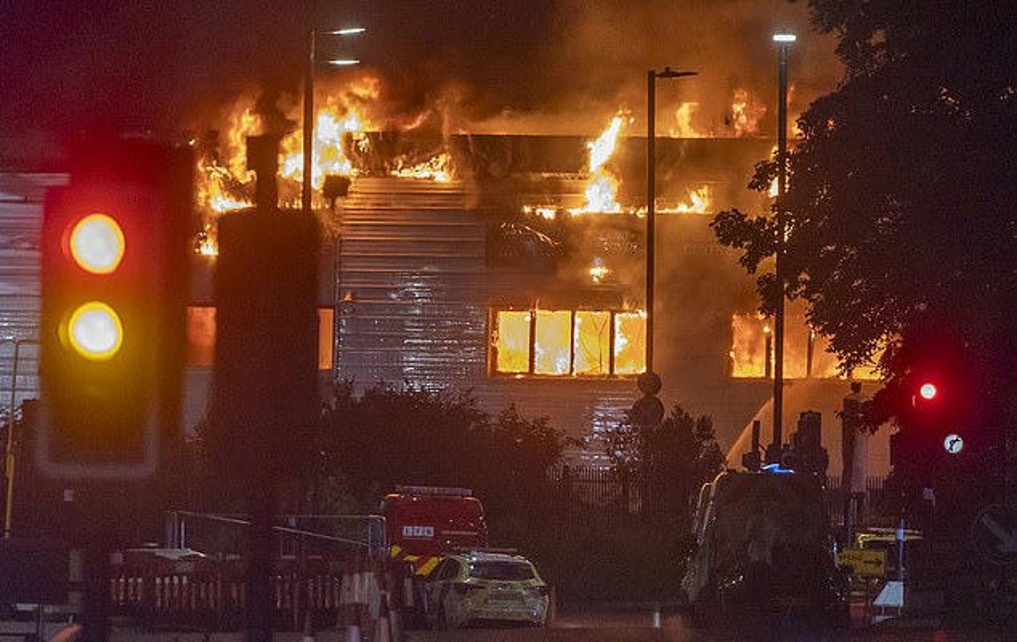 Vehicle maintenance warehouse fully engulfed by flames.