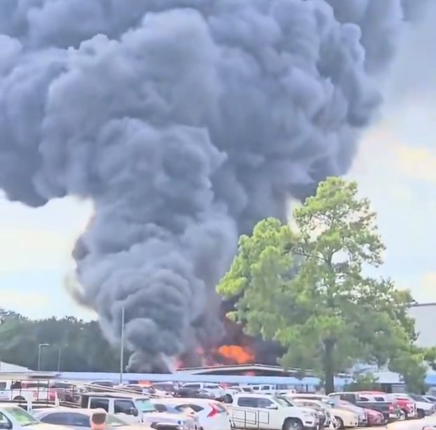 Visible flames and heavy black smoke plume from the Howard Industries paint booth fire in Laurel Mississippi