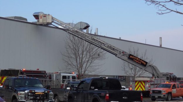 Rockland Fire and EMS ladder deployed on the roof of Fisher Engineering during machine fire response.