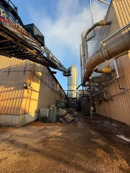 Aerial view of process ductwork and equipment at a wood-processing facility during firefighting operations